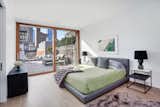 Master bedroom with 12' ft wall of Weiland mahogany and glass doors opening to a private terrace. 