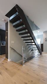 Open risers and glass railings maintain an open flow of space.