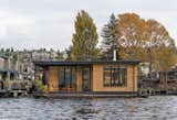 This floating home by Atelier Drome features a wraparound Ipe deck that is accessible from every room. The building is clad in horizontal cedar siding that adds style and warmth to the structure sitting on Lake Union. A cedar slat screen provides privacy from the dock.