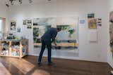 The studio is designed as an open workspace with a lot of natural light and high ceilings along with a trap door from the second story to lower large paintings.