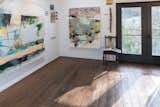 The studio is designed as an open workspace with a lot of natural light and high ceilings along with a trap door from the second story to lower large paintings.