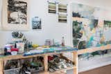 The studio is designed as an open workspace with a lot of natural light and high ceilings along with a trap door from the second story to lower large paintings.