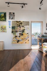 The studio is designed as an open workspace with a lot of natural light and high ceilings along with a trap door from the second story to lower large paintings.