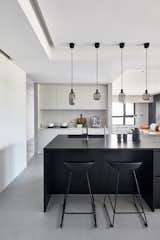 Kitchen, Concrete Floor, Pendant Lighting, and White Cabinet Kitchen  Photo 2 of 25 in Blackened Wood Apartment by CTT Architects