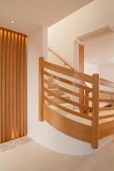 The Italian wood curved fascia railing for the new stair proves that modern doesn't need be stark or predictable.