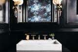 Kohler marble sink and gold faucet add modern drama.