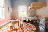 The custom-built tree fort-inspired bunk bed provides lofted space for the small room with the ladder doubling as structural support and an element of play.