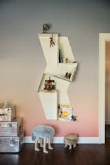 Trapezoid-shaped shelving units arranged in a zigzag configuration on the wall provide another dimension.