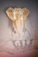In the far corner of the room, a three dimensional wooden bust of an elephant emerges from the mural. The bust is mapped with video projections enabled by Lightform.