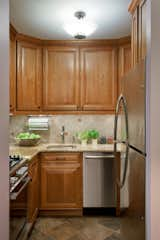 The kitchen, although small, packs a lot of storage punch! Going for a warmer more rustic look here, we used a tumble marble for the backsplash with inserts of a copper decorative tile that we placed throughout.
