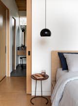Bedroom, Night Stands, Bed, Cork Floor, and Pendant Lighting Pocket doors are a space-saving strategy in an efficiently-planned master suite  Photo 10 of 12 in The Wriff Residence by Guggenheim Architecture + Design Studio