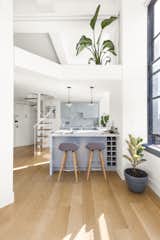 First, they ripped out the kitchen’s outdated Formica counters and ’70s-era cabinets, and completely gutted the old bathroom. The kitchen ceiling was cut away from the windows by about 18 inches to make more of the windows visible. An entryway closet was reduced so that the view from the kitchen window could be seen from the entrance of the apartment.