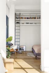 Another view of the bedroom, showcasing the high storage shelves accessible by a ladder.