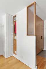 A hidden wall cabinet holds luggage and other items.