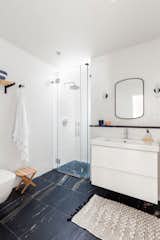 The shower, a vertical space with a skylight, is flooded by day with natural sunlight, making it feel almost like it’s outside. 