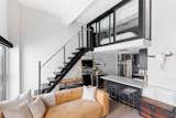 The apartment is a mix of flat, modern, and cool elements such as the steel staircase and black cabinetry. 