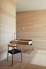 A cantilevered birch and plywood desk appears to effortlessly float in midair. The wood box is attached to the wall with a blackened structural steel angle. "It’s a place to make a phone call, put down keys, plug in the iPhones," says Ryall. "We liked the contrast of the structural steel and the more refined wood box, kind of the like the house, which itself is full of contrasts—rough/smooth, dark/light, open/closed."