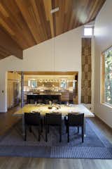 Dining Room, Chair, Table, Lamps, Pendant Lighting, and Dark Hardwood Floor Great room dining area and kitchen beyond.  Photo 7 of 10 in The Frederick McKeehan Residence by Daniel Frederick