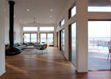 Living Room, Sectional, Coffee Tables, End Tables, Recliner, Floor Lighting, Ceiling Lighting, Recessed Lighting, Medium Hardwood Floor, and Hanging Fireplace  Photo 2 of 30 in Ocean View House by DAS Studio