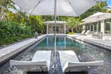 The swimming pool was resurfaced, and a shelf was added for lounging. The coping and paving around the pool was updated to White Quartzite giving it a modern, cleaner finish.