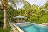 Outdoor seating with cover was designed to protect from the harsh summer sun of the Florida Keys as well as create an extra space for privacy and relaxation. Lush tropical planting was designed around the property for privacy and shade with the clean lines of the pool extending to the poured-in-place concrete pavers.