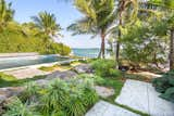 Boulders and tropical planting in groups were used to define space throughout the garden while poured-in-place concrete pavers help complete the clean lines of the property.