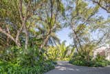 The grand ficus trees are the focal point and entry to this Florida Keys waterfront property, creating both shade and privacy to this dramatic entrance.