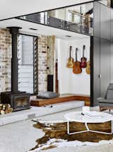 Living Room, Bench, Recessed Lighting, Coffee Tables, Chair, Terrazzo Floor, and Wood Burning Fireplace  Photo 5 of 8 in A Brisbane Architect Designs a Light-Filled Addition For Her Brother
