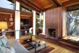 Living Room, Standard Layout Fireplace, Wood Burning Fireplace, Table Lighting, Pendant Lighting, Medium Hardwood Floor, Rug Floor, Coffee Tables, Sofa, and Shelves  Photo 10 of 11 in A Perfectly Preserved Midcentury Pad in Northern California Asks $1.975M
