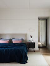 Bedroom, Bed, Night Stands, Wall Lighting, Light Hardwood Floor, and Rug Floor  Photo 9 of 10 in A Run-Down Melbourne Bungalow's Makeover Embraces Light and Family Life
