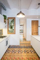 Kitchen, White Cabinet, Ceramic Tile Floor, Ceramic Tile Backsplashe, Pendant Lighting, Cooktops, and Wall Oven  Photo 10 of 51 in Specific design elements by J.O. from A Dramatic Apartment Renovation in Barcelona Features Salvaged Tile and Brick