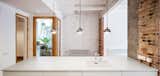 Kitchen, Pendant Lighting, and Drop In Sink  Photo 6 of 14 in A Dramatic Apartment Renovation in Barcelona Features Salvaged Tile and Brick