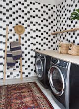The laundry room features custom wallpaper designed by Samuel.