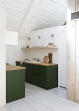 Here is a view into the kitchen, which received IKEA cabinet boxes with Semihandmade drawer and door fronts painted Chard from Behr, by Samuel. The refrigerator is a KitchenAid model tucked under the butcher block counter and covered with a panel.