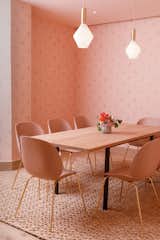 At the Brooklyn outpost of The Wing, the all-women co-working space, a meeting room is swathed in a mature color palette of monochromatic pinks with matching un-upholstered Beetle chairs. The walls are covered with wallpaper depicting the the face of women.