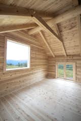 Bedroom and Light Hardwood Floor In the fourth section of the cabin, there's a large North-facing window for observing northern lights.  Photo 7 of 8 in This Astounding Cabin in Norway Is a Patchwork of Different Materials