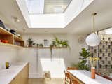 In the combined kitchen and dining room, a skylight lets in lots of sunlight, and the table overlooks the courtyard.