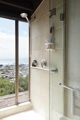 A shower with floor-to-ceiling glazing fosters indoor/outdoor flow.