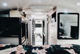 Looking back toward the front of the bus, more storage becomes visible. The pink dresser on the right holds the family's clothes. The gray dresser to the left incorporates a standing desk for Brandon and hides mechanicals. 