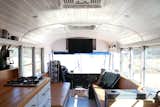 A look at the view toward the driver's seat and front of the bus. The family built two camel leather couches facing one another for the living area. A table can be placed between them for family meals. Built-in storage in the couch bases hold everything from extension cords and leveling blocks to board games and kettle balls. The armrests also open up and have outlets inside. "I intentionally built the five-inch ledge behind the couches for our coffee in the morning," says Ashley. "The kids also use this ledge to play with their LEGO mini figs or their tech decks. It serves its purpose well!"