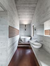The use of walnut, red concrete, and reinforced concrete remains consistent throughout the master bath.