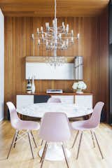 In the dining room, a marble-topped Saarinen table is surrounded with pink Eames chairs.