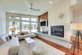 The open-concept living room features a fireplace clad in white brick.