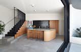 Kitchen, Undermount, Concrete, Ceiling, Concrete, Concrete, Refrigerator, and Wood In the new kitchen, oak timber veneer joinery unites concrete floors and counters.  Kitchen Concrete Concrete Ceiling Photos from An Australian Home's Brick Addition Creates a Private Backyard Haven