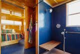 Inside this trailer, the blue shower and floor contrast warmly with the birch interior.

