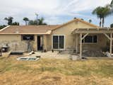 A pergola tacked onto the rear facade darkened the home's interior, and the indoor/outdoor connection was disjointed.  Photo 1 of 12 in Before & After: A Neglected 1960s Ranch-Style Home Gets a Sunny Outdoor Connection