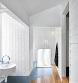 Bath Room, Ceramic Tile Wall, Medium Hardwood Floor, Ceramic Tile Floor, Subway Tile Wall, Tile Counter, Wall Mount Sink, and Pendant Lighting The angled tile floor-pad designates the entrance to the bathtub area.

  Photo 12 of 12 in A Small Australian Cottage Becomes an Airy Gathering Hub