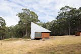 The 301-square-foot cabin is situated on 99 acres on Bruny Island, an island off the coast of Tasmania. For the exterior, the architects have chosen materials that "comply with the Bushfire Attack Level of 19," they explain, including bushfire resistant wood and zincalume metal. The cabin collects its own rainwater—storage tanks are underground for an uncluttered look—and the roof sports solar panels.