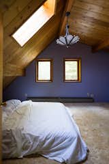 Before: Purple walls, fluffy carpeting, and a boring chandelier would have to go, but the pine paneling stayed.  Photo 4 of 11 in Budget Breakdown: A Creative Couple Rehab a Vermont Cabin for $18K