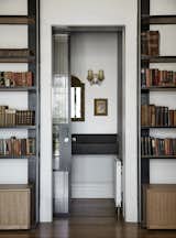 The architects repeated the use of glass and steel on internal openings as well, such as in the pocket door for this hidden nook, so as to produce visual consistency throughout the home.